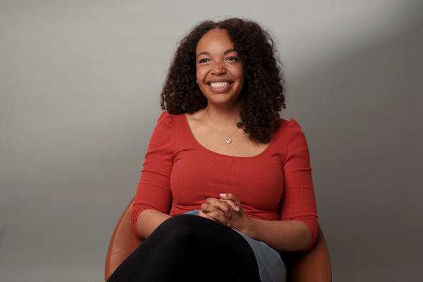 A picture of Hannah Chukwu wearing a bright orange top.