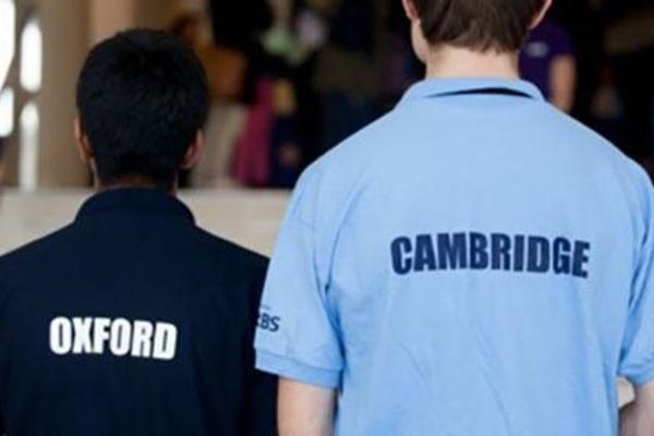 the backs of 2 students with Oxford and Cambridge t-shirts