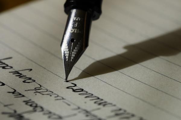 Image of someone writing with a fountain pen 