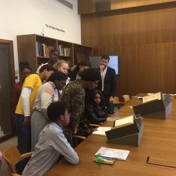 Group of students at the Weston Library looking at books on a table