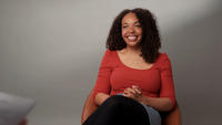 A picture of Hannah Chukwu wearing a bright orange top.